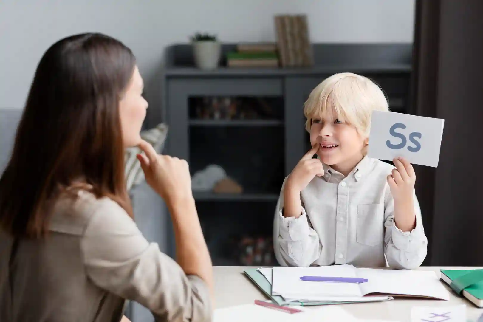 young-woman-doing-speech-therapy-with-little-boy (1) speech and language therapy